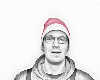 Porträt eines Mannes in Weihnachtsmütze vor weißem Hintergrund.