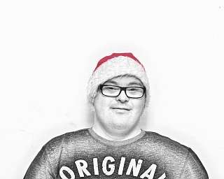 Lächelnder Mann trägt eine rote Weihnachtsmütze vor weißem Hintergrund.