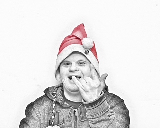 Mann mit Weihnachtsmütze zeigt ein Handzeichen und lächelt.