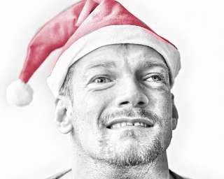 Lächelnder Mann trägt eine rote Weihnachtsmütze.