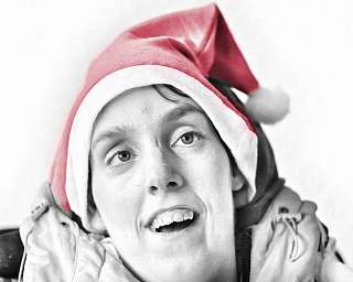 Porträt einer Frau in Weihnachtsmütze, lächelnd.