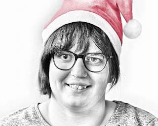 Porträt einer Frau in einem Weihnachtsmannhut.