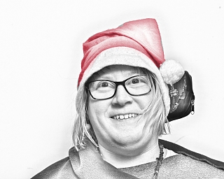 Lächelnde Frau trägt eine rote Weihnachtsmütze und Ohrenschützer.